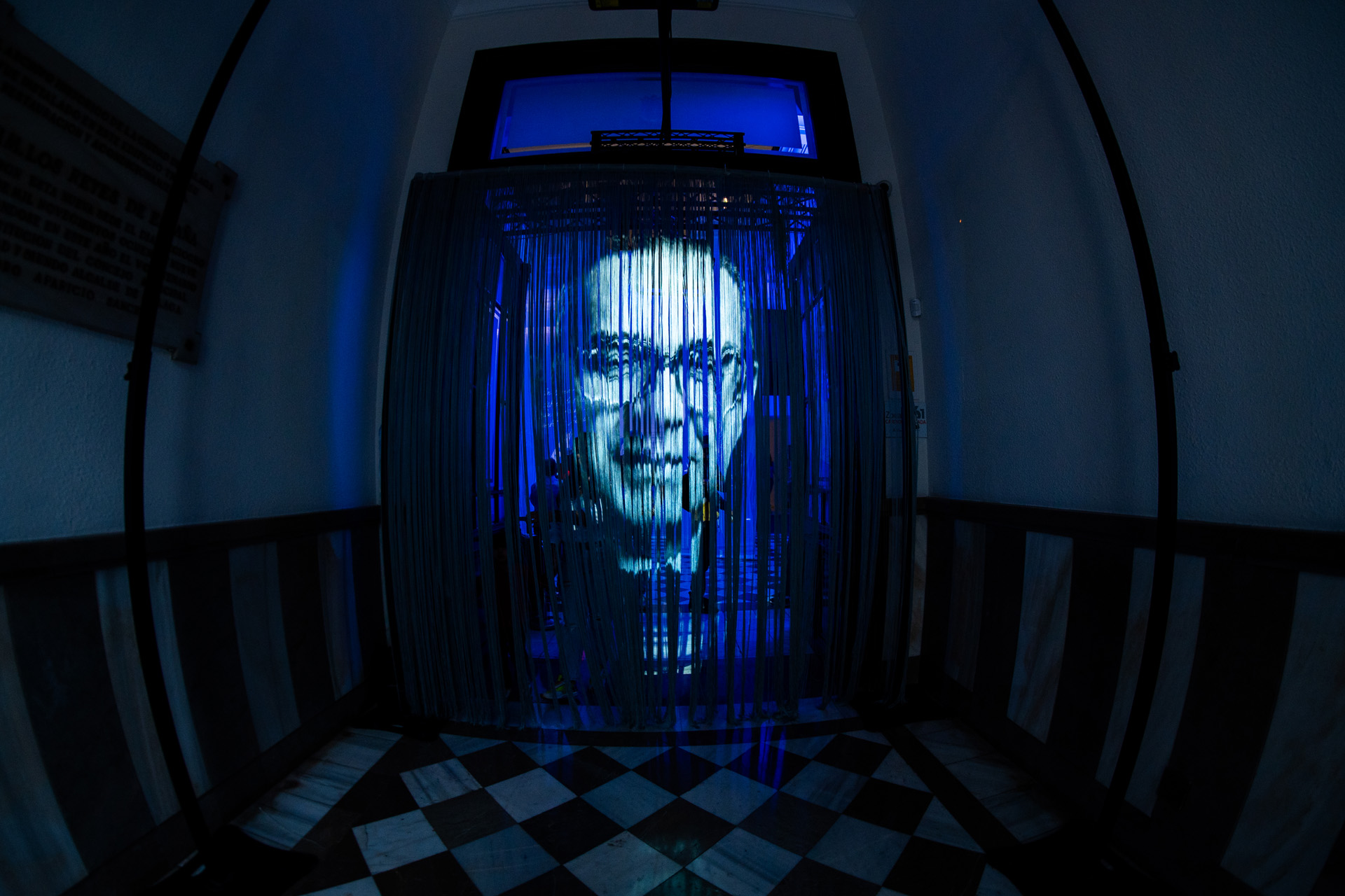 Proyección del rostro de Rafael Pérez Estrada en la puerta del Archivo Municipal recitando un poema